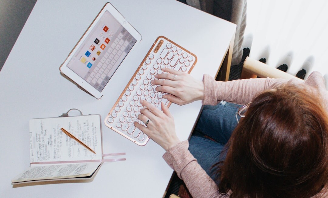 Hands typing on a laptop next to a production schedule notebook